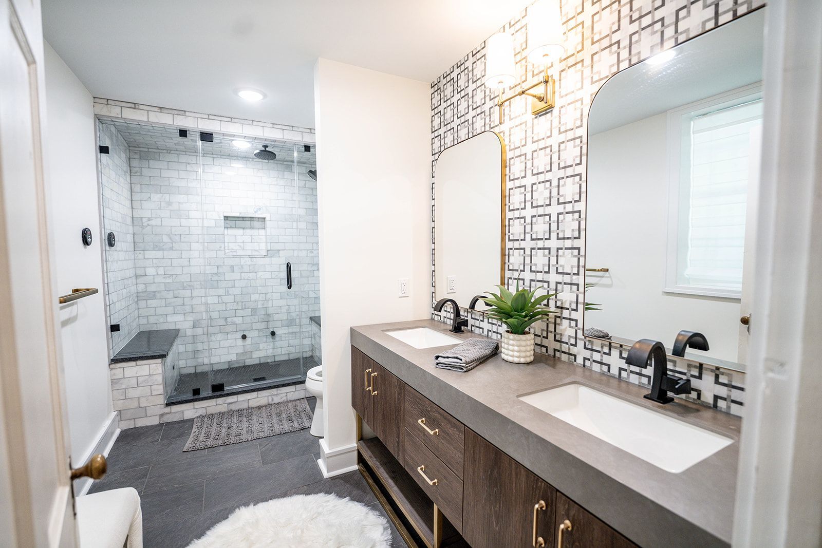 A bathroom with two sinks and a walk in shower.