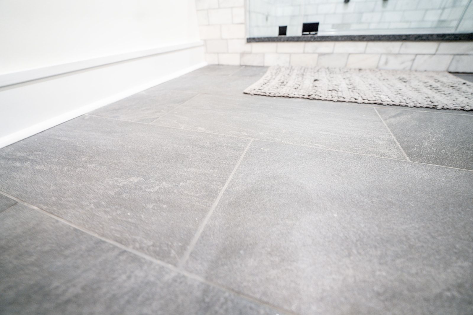 There is a rug on the floor in the bathroom.