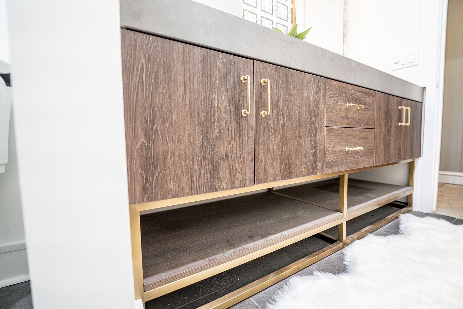 A bathroom vanity with wooden cabinets and drawers.