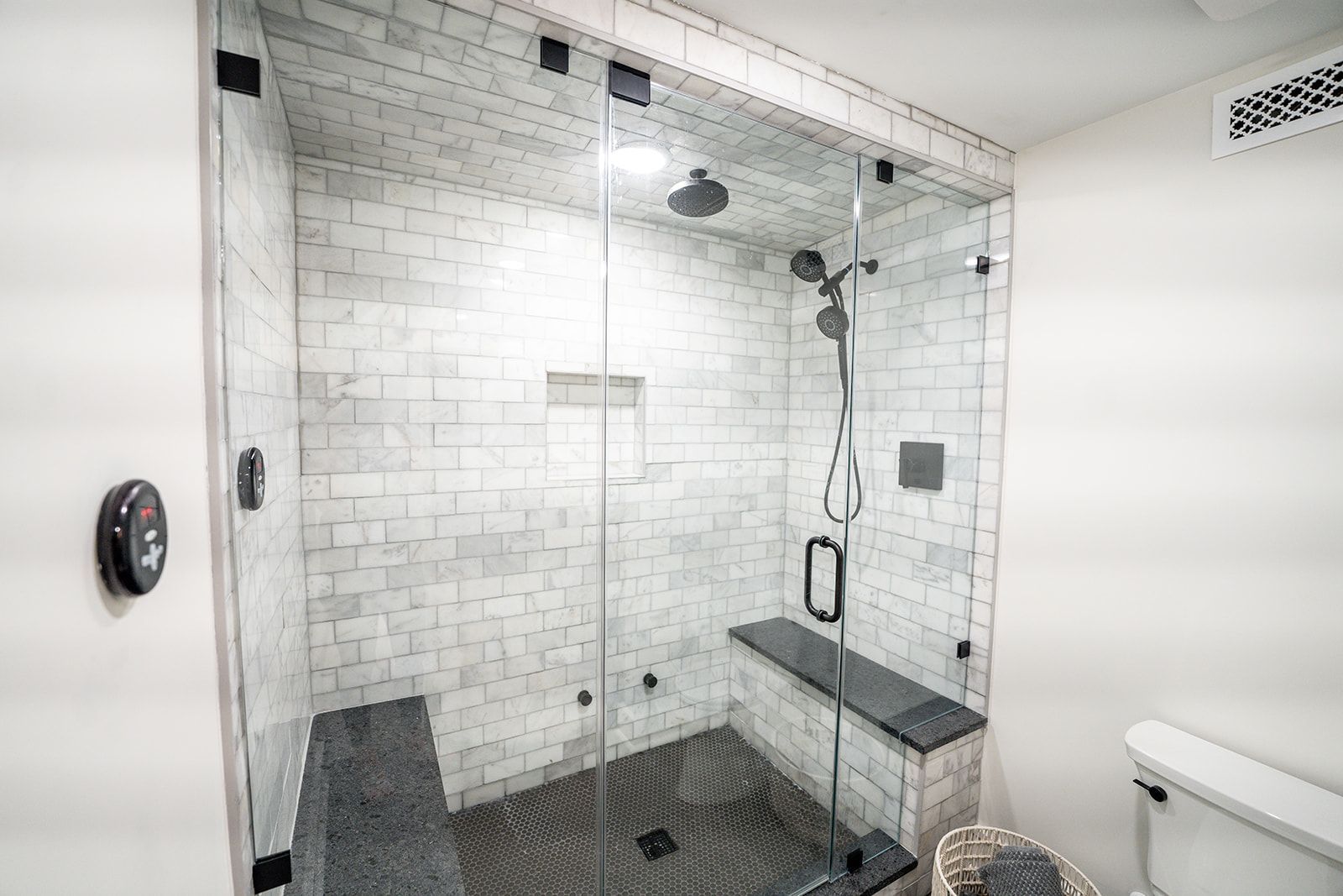 A bathroom with a walk in shower and a toilet.