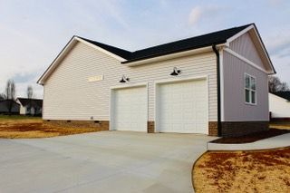 A white garage with two white garage doors and a concrete driveway.