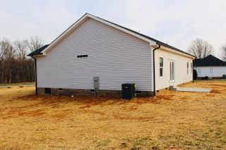 A white house is sitting in the middle of a field.
