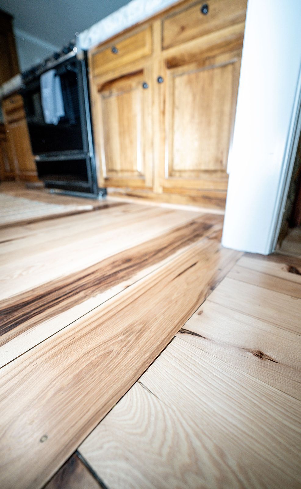 A kitchen with hardwood floors and wooden cabinets.