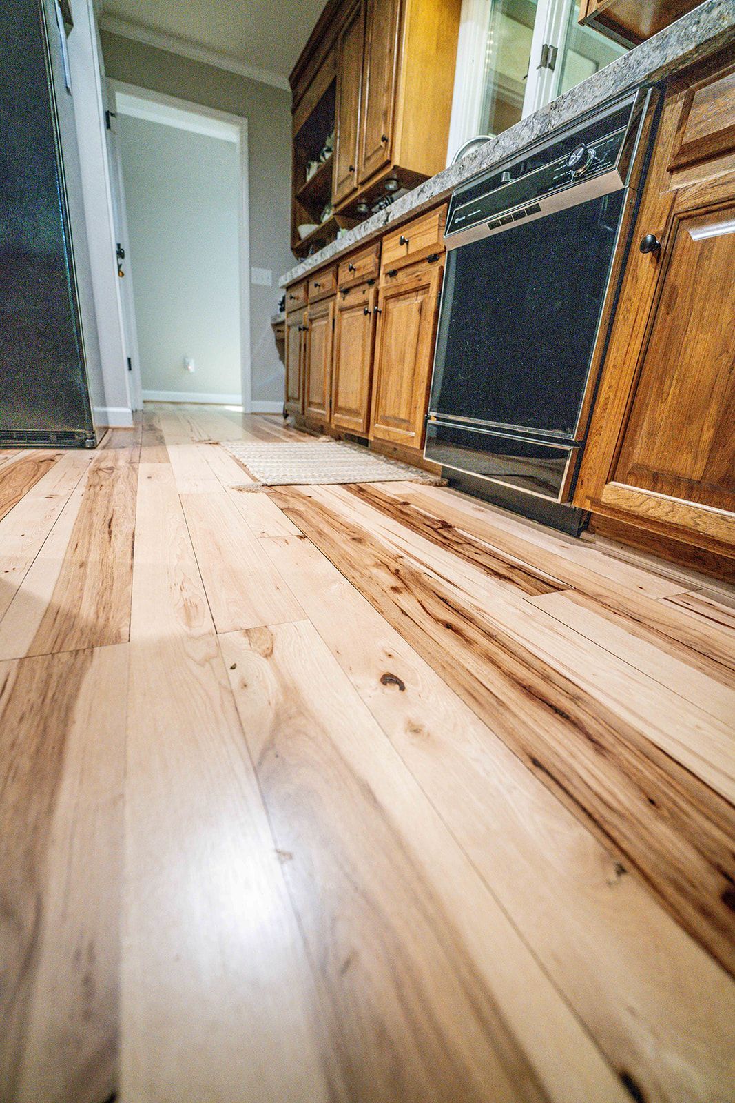 A kitchen with hardwood floors and stainless steel appliances.