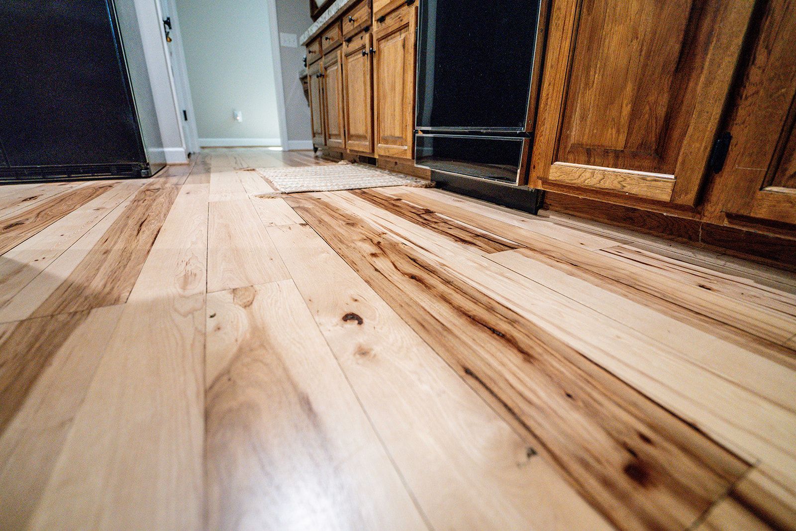 A kitchen with a wooden floor and wooden cabinets.