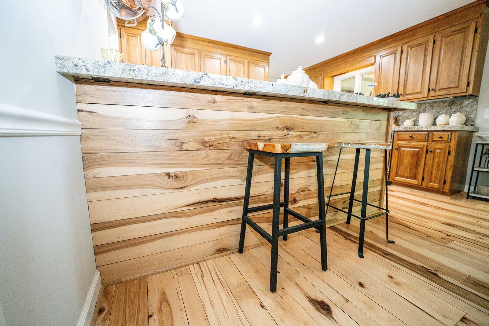 A kitchen with a wooden counter top and stools.