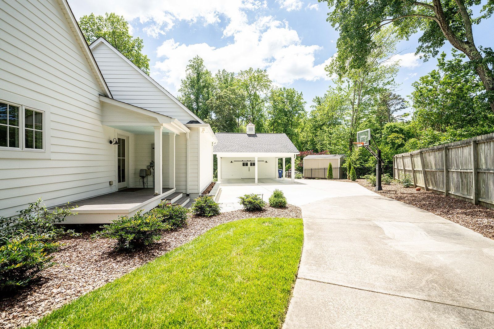 A white house with a driveway leading to it.