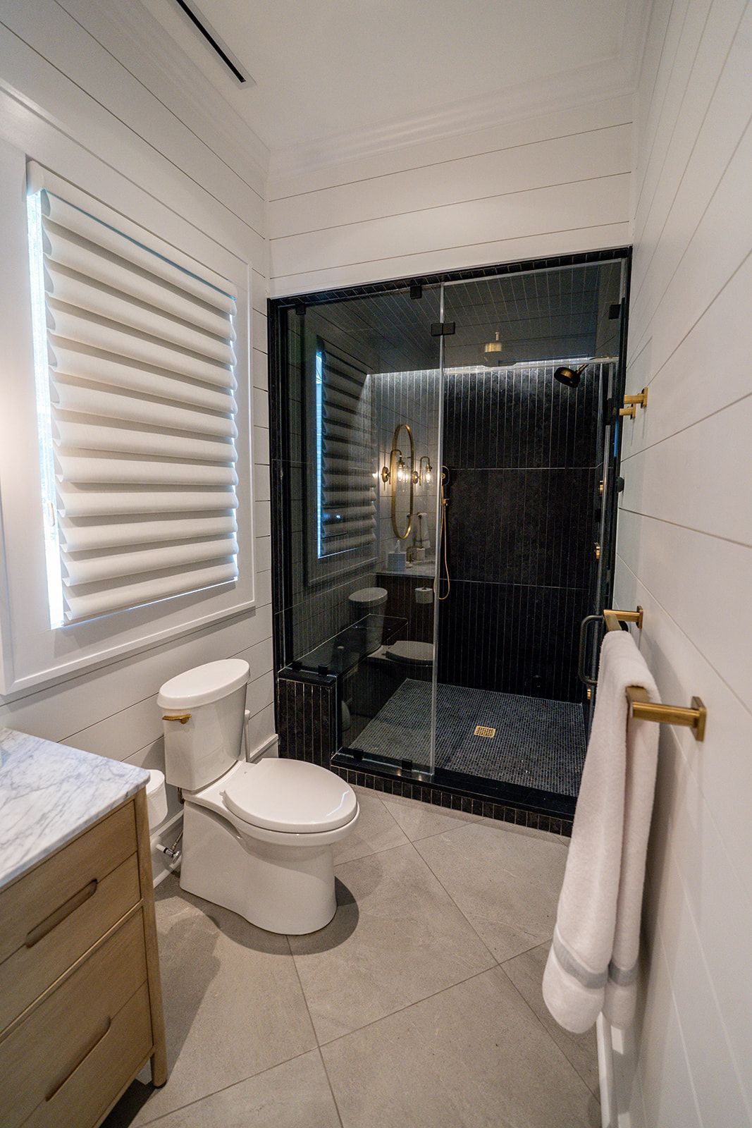 A bathroom with a toilet , sink , and shower.