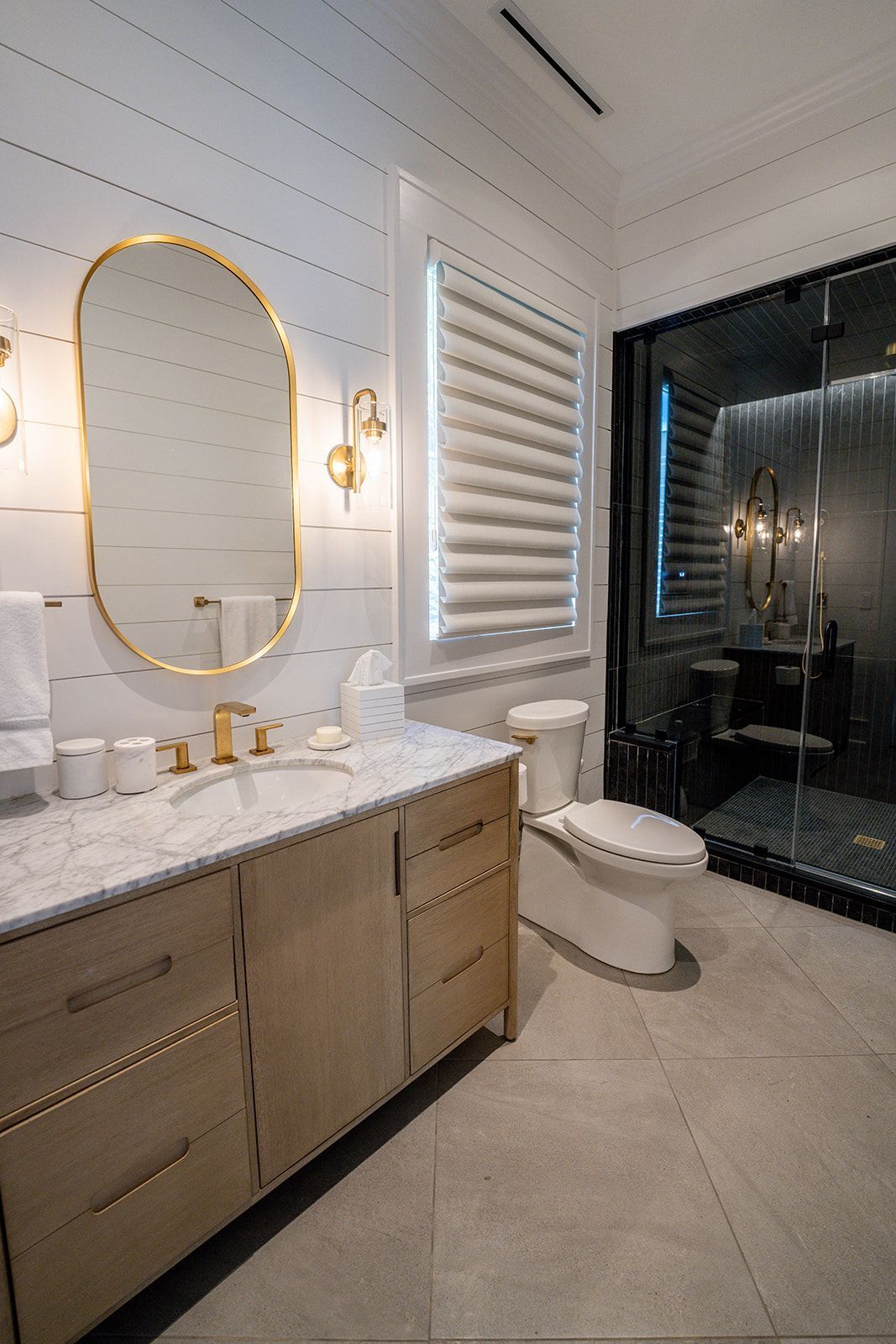 A bathroom with a sink , toilet , mirror and shower.