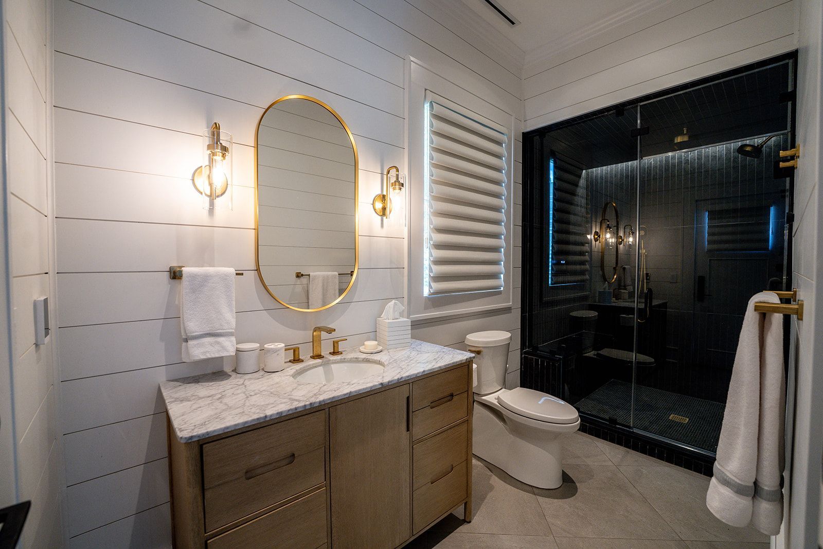 A bathroom with a sink , toilet , mirror and shower.