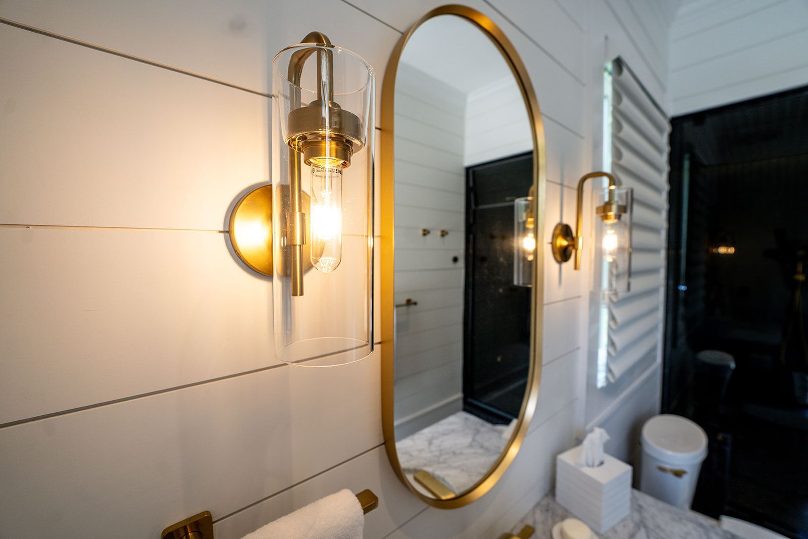 A bathroom with a large mirror and two lights on the wall.