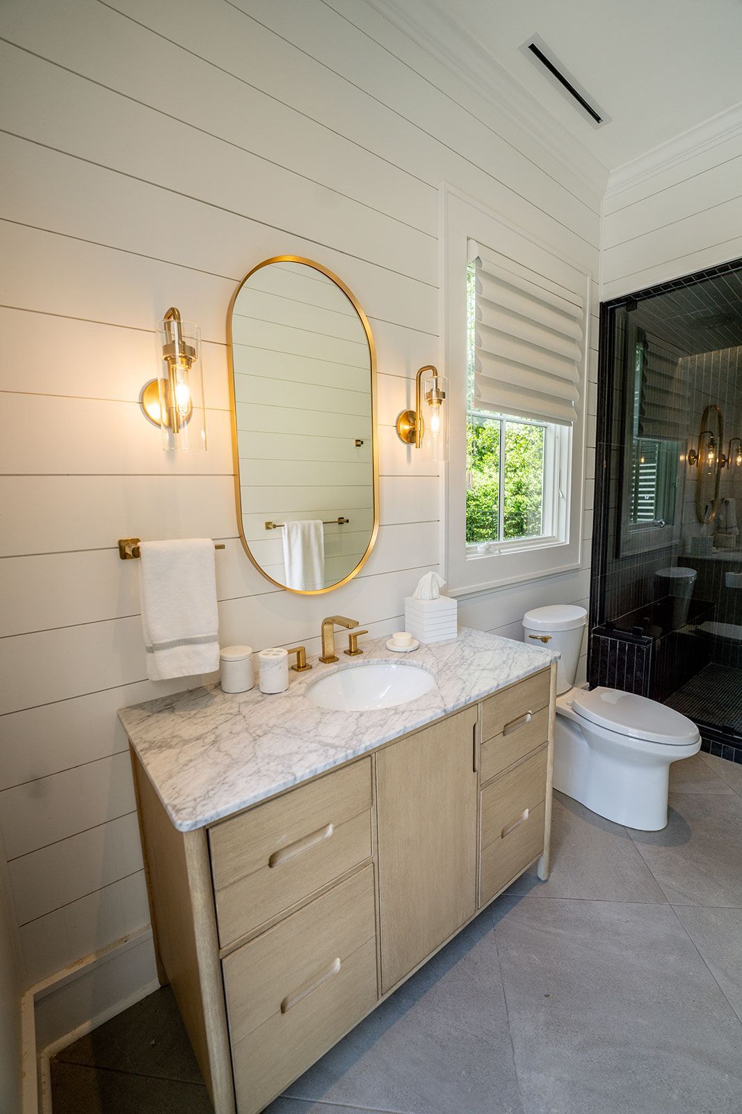 A bathroom with a sink , toilet and mirror.