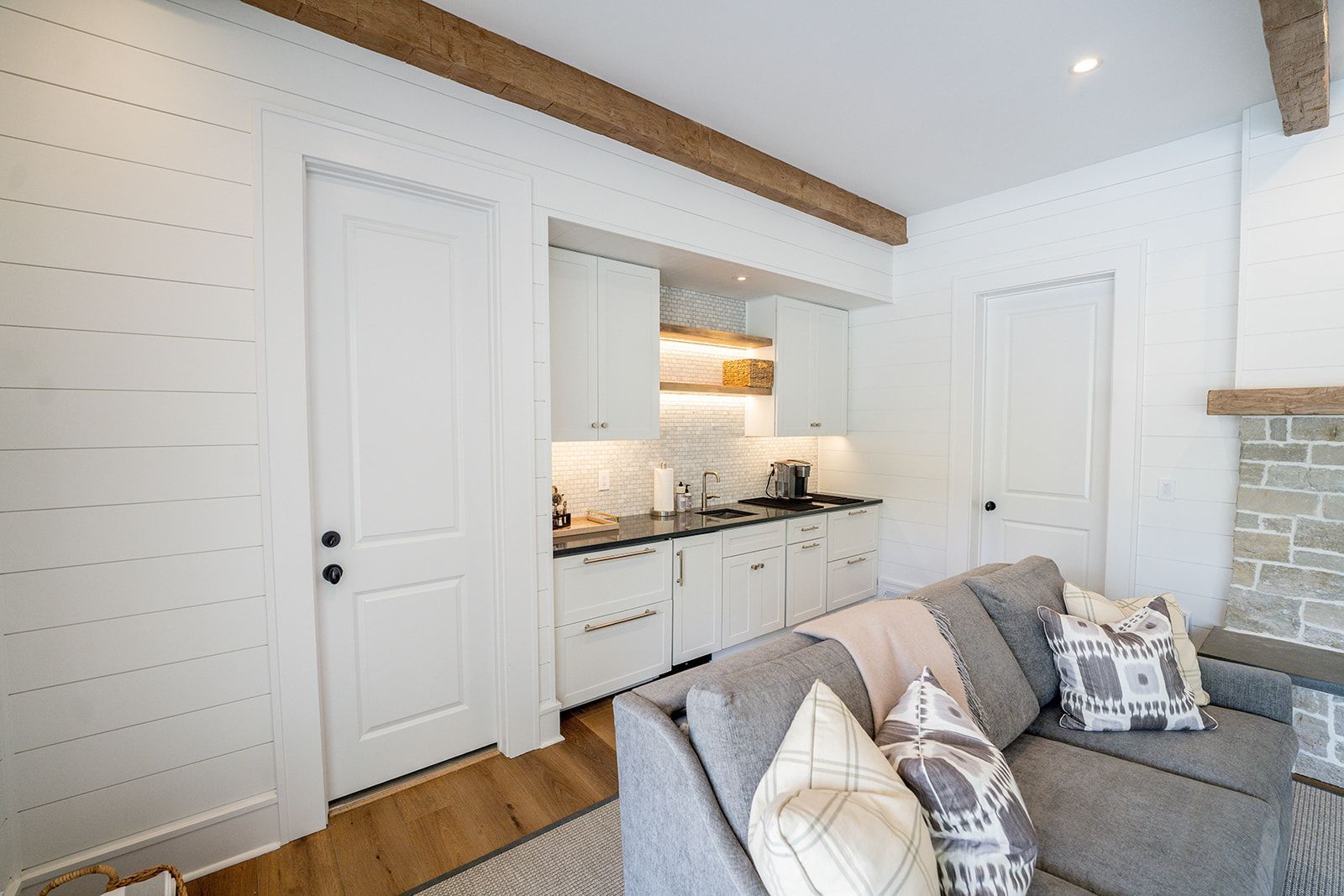 A living room with a couch and a kitchen in the background.