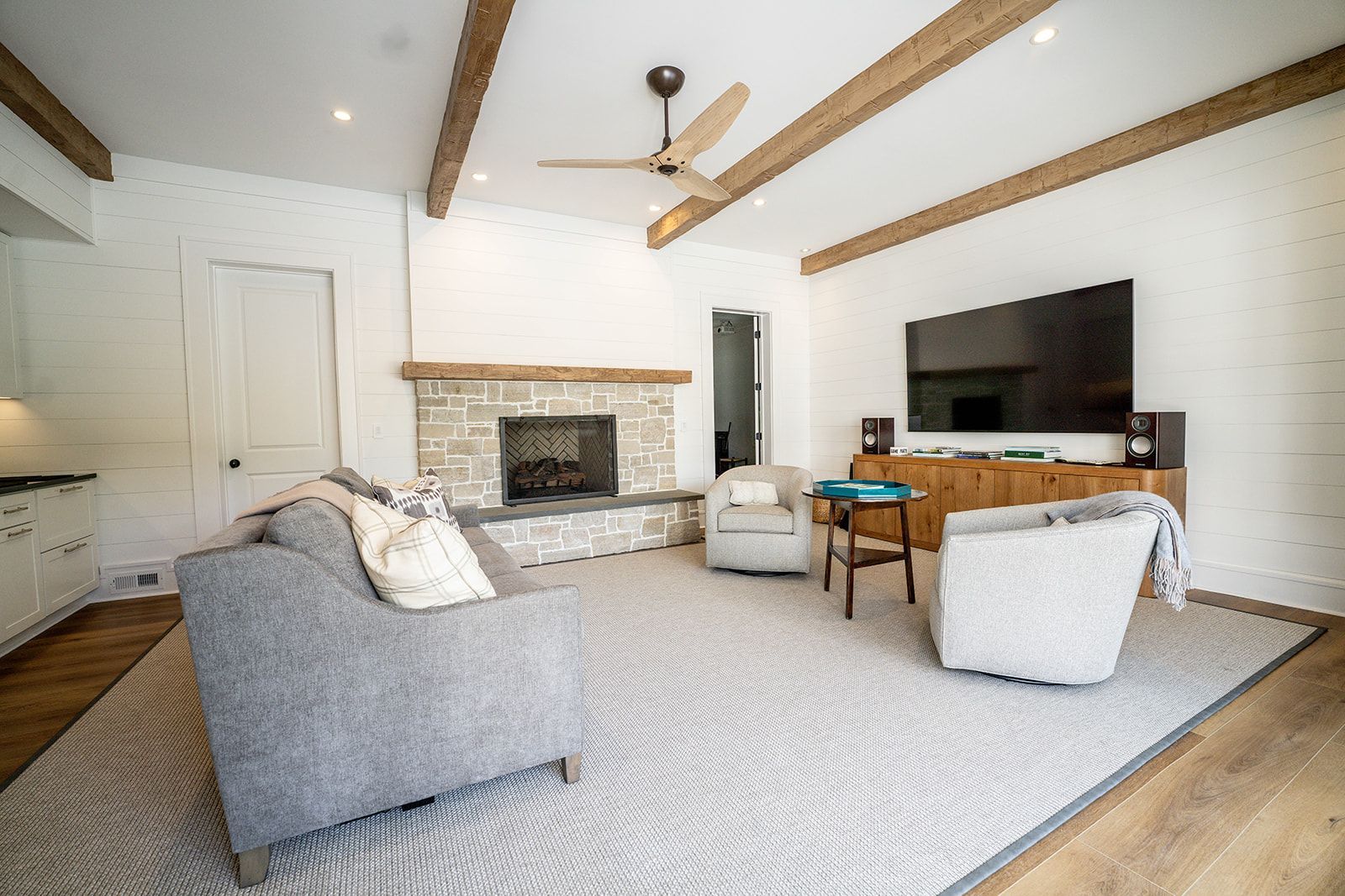 A living room with a couch , chairs , a fireplace and a flat screen tv.