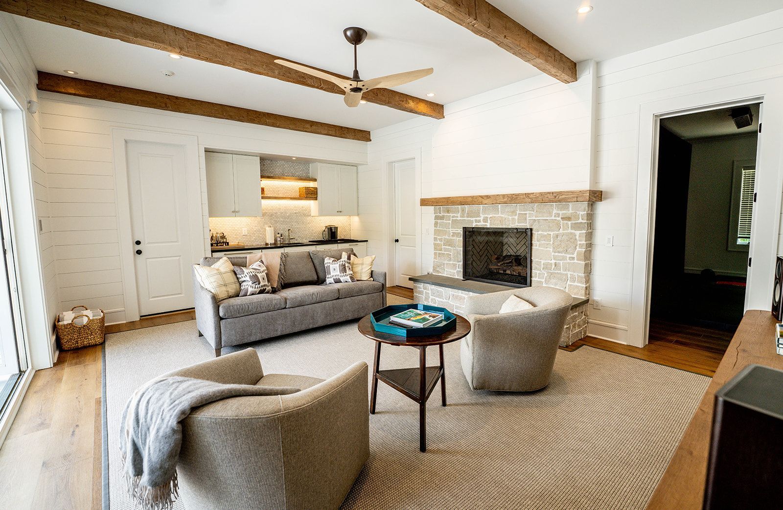 A living room with a couch , chairs , table and fireplace.