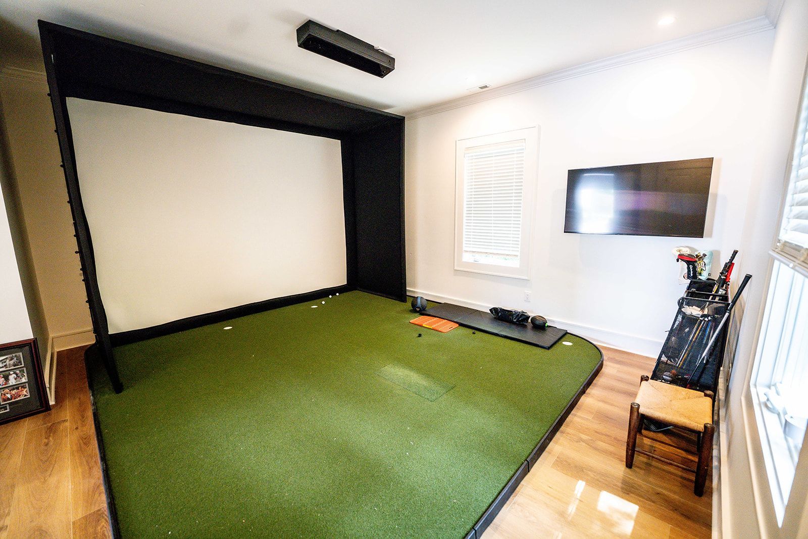 A room with a green carpet and a projector screen.