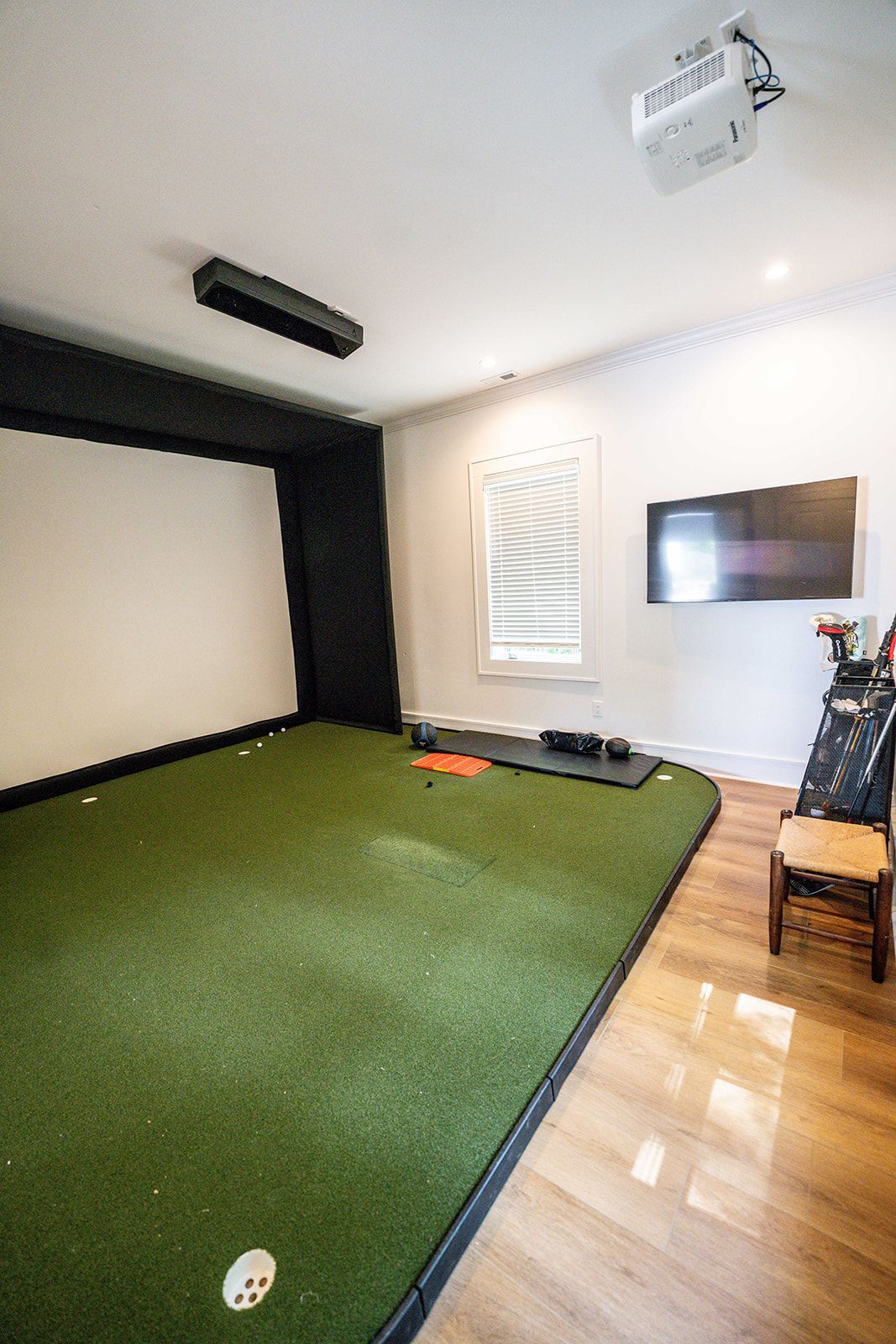 A room with a green carpet and a flat screen tv.