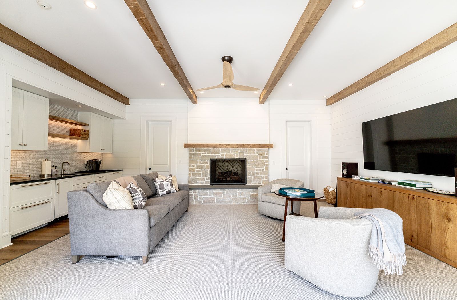 A living room with a couch , chair , fireplace and television.