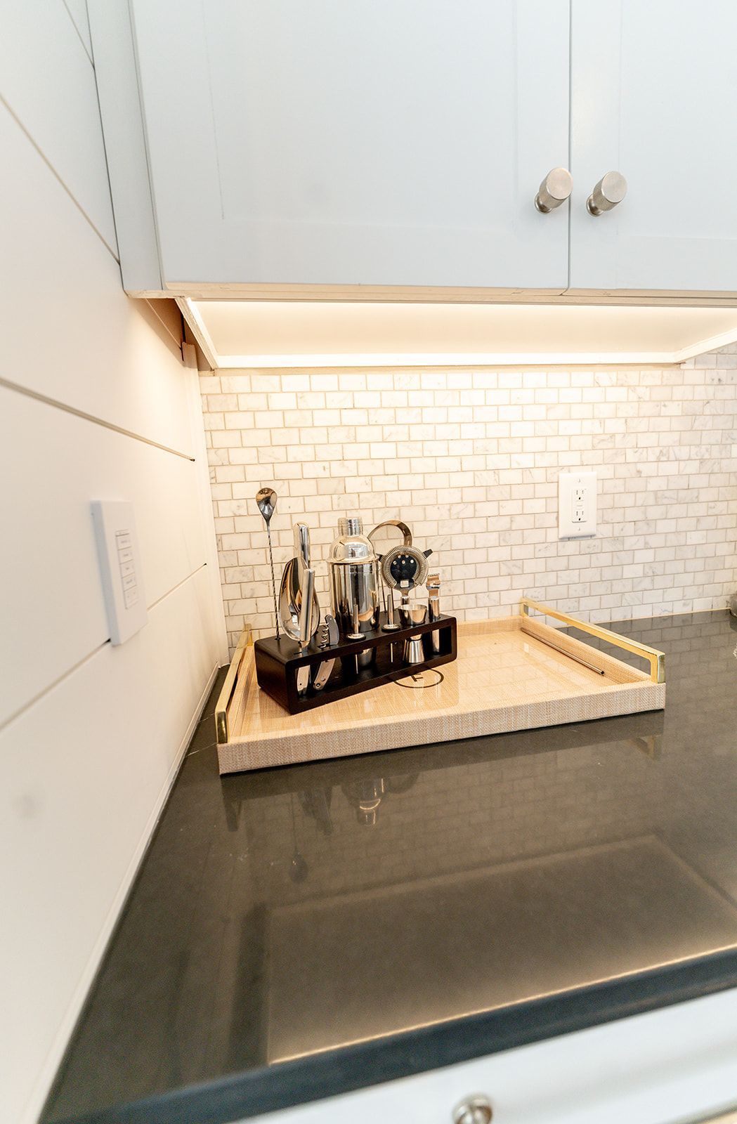 A kitchen counter with a tray of utensils on it.