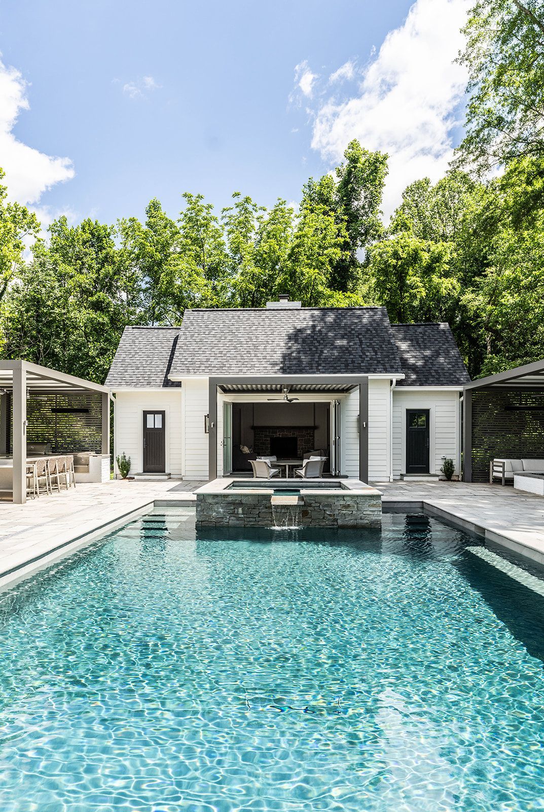 There is a large swimming pool in front of a house.
