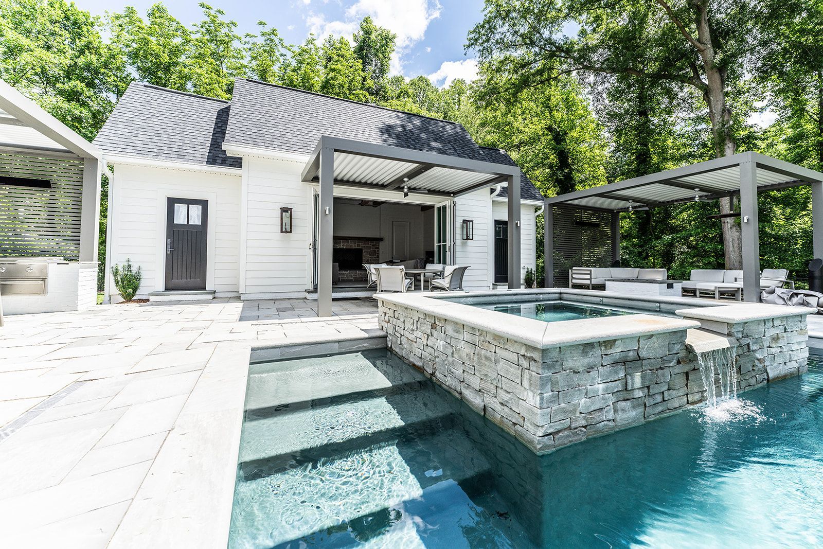 There is a large swimming pool in the backyard of a house.