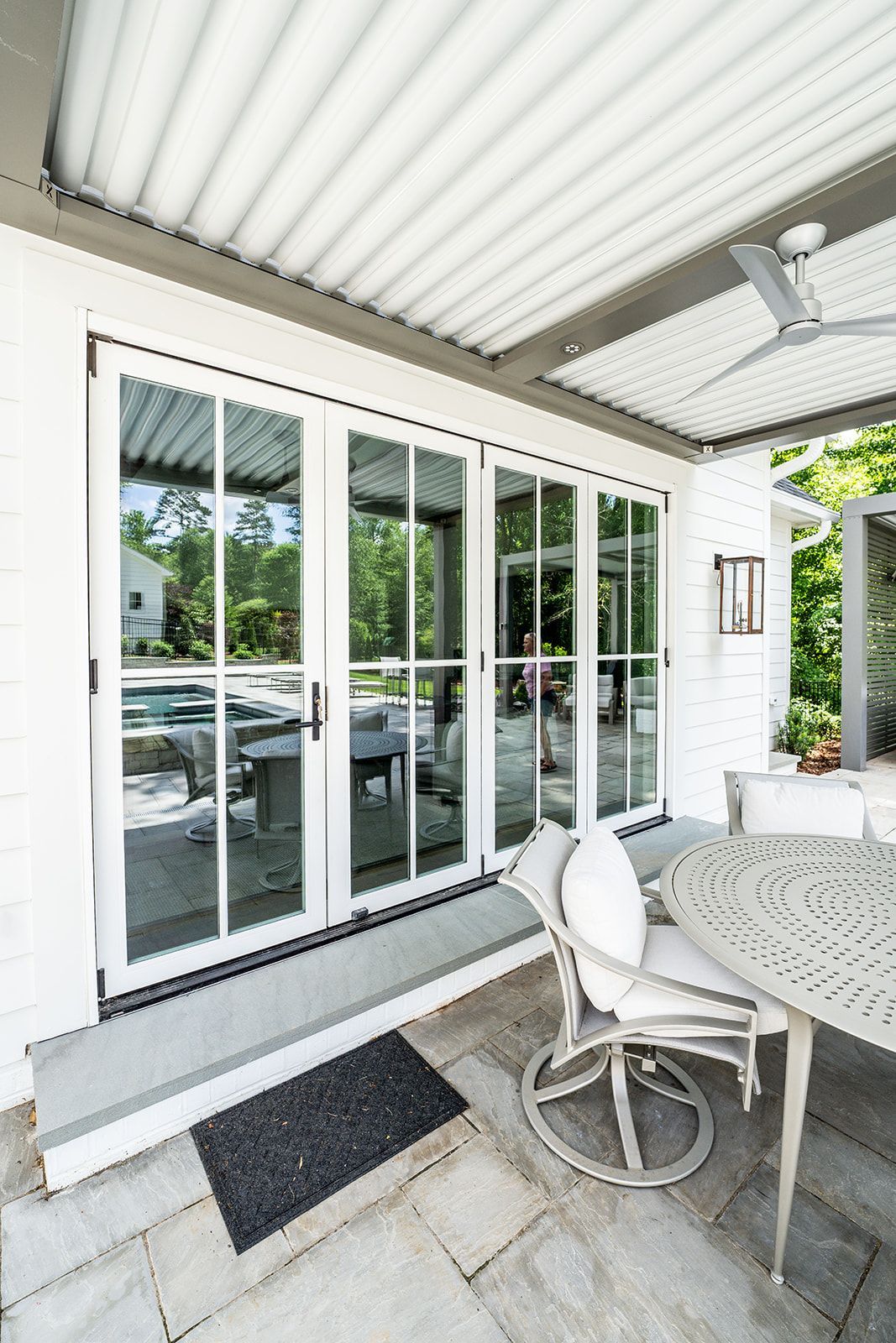 A patio with a table and chairs and a ceiling fan.
