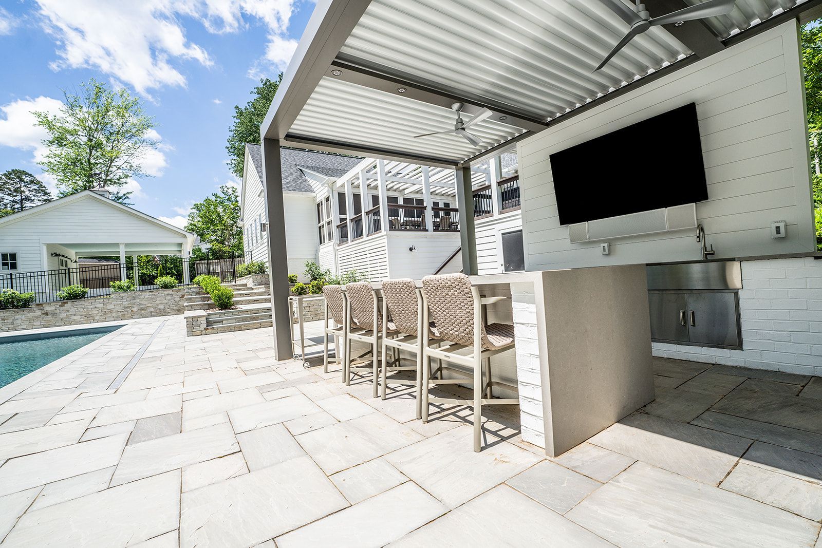 A patio with a kitchen and a television on the wall.