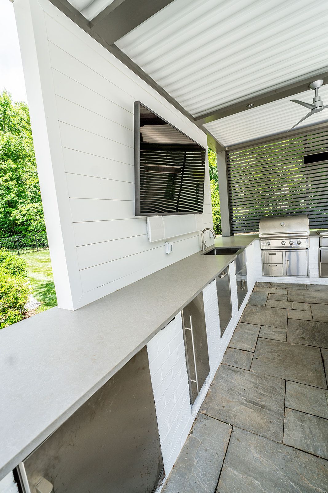 A kitchen with a grill and a television on the wall.