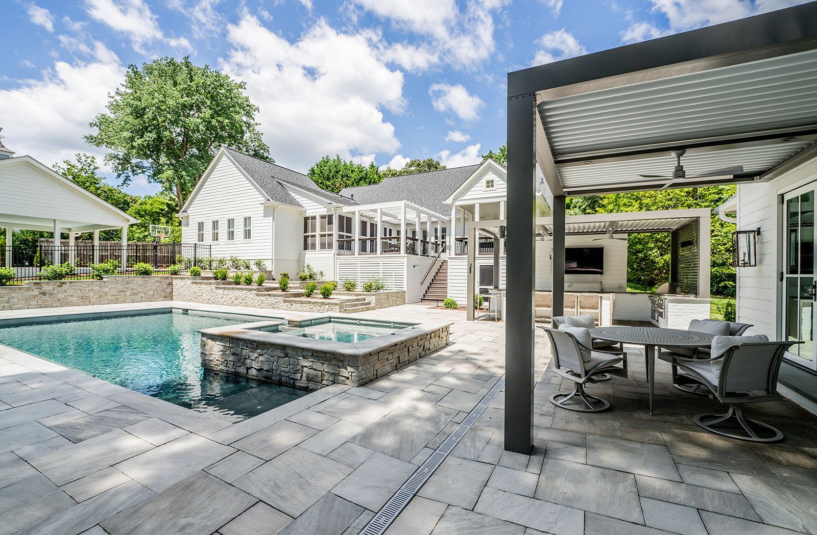 There is a large swimming pool in the backyard of a house.