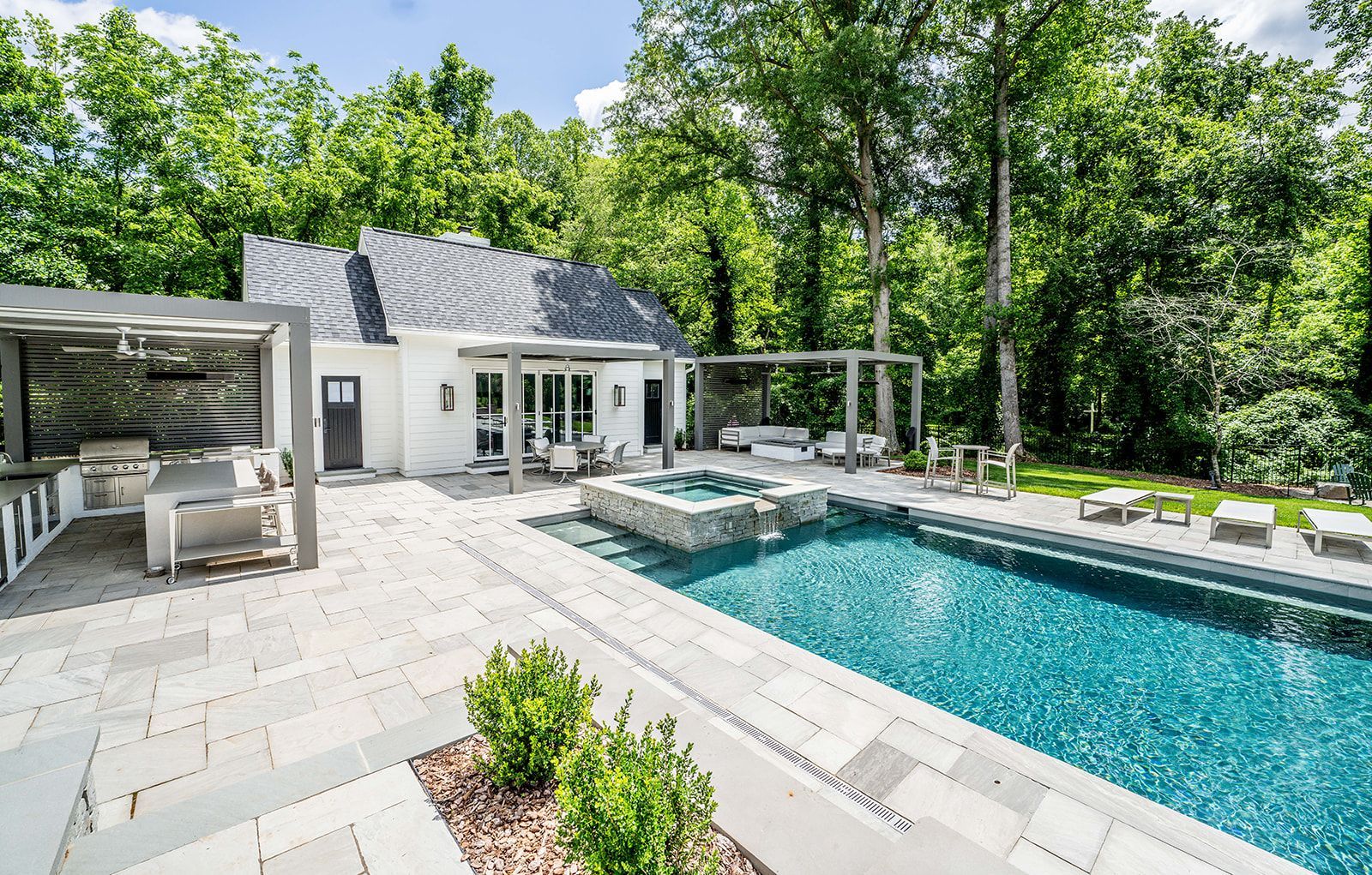 There is a large swimming pool in the backyard of a house.