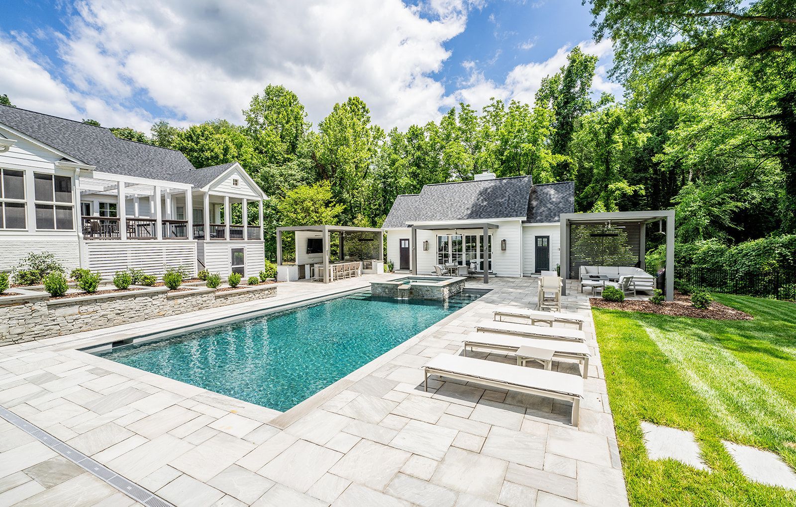 There is a large swimming pool in the backyard of a house.