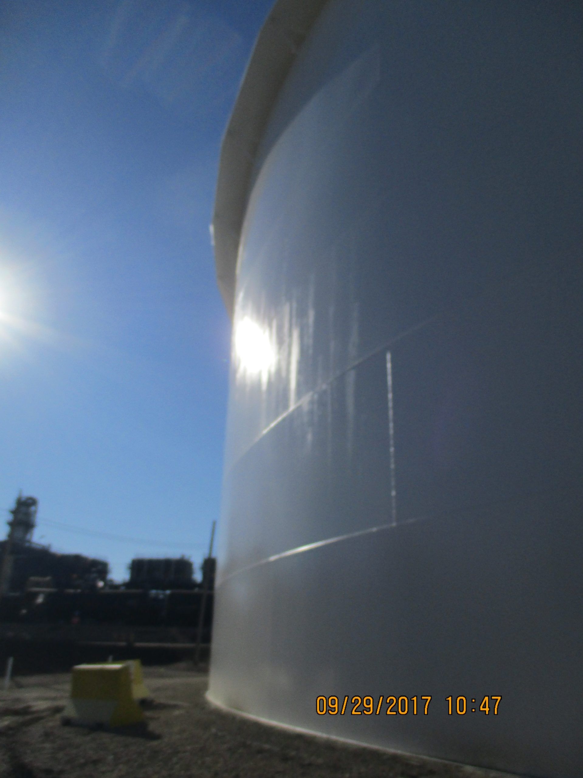 Close-up side angle of an industrial tank with a glossy white protective coating