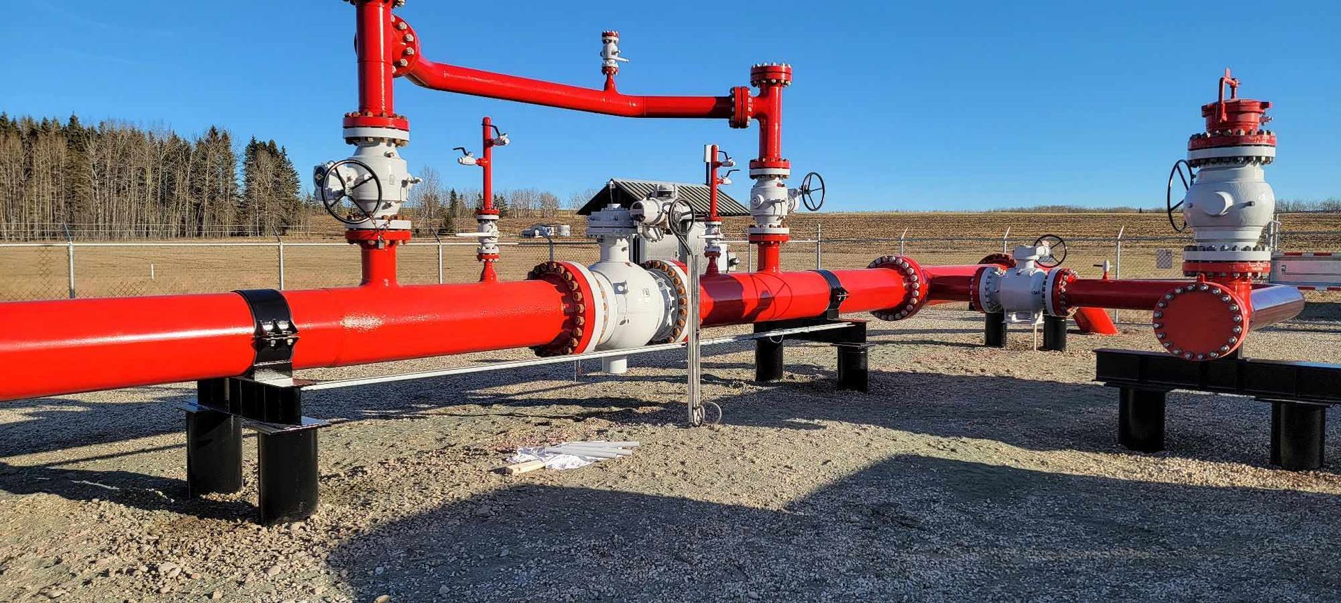 Red protective coating applied to above-ground oil and gas pipeline valves