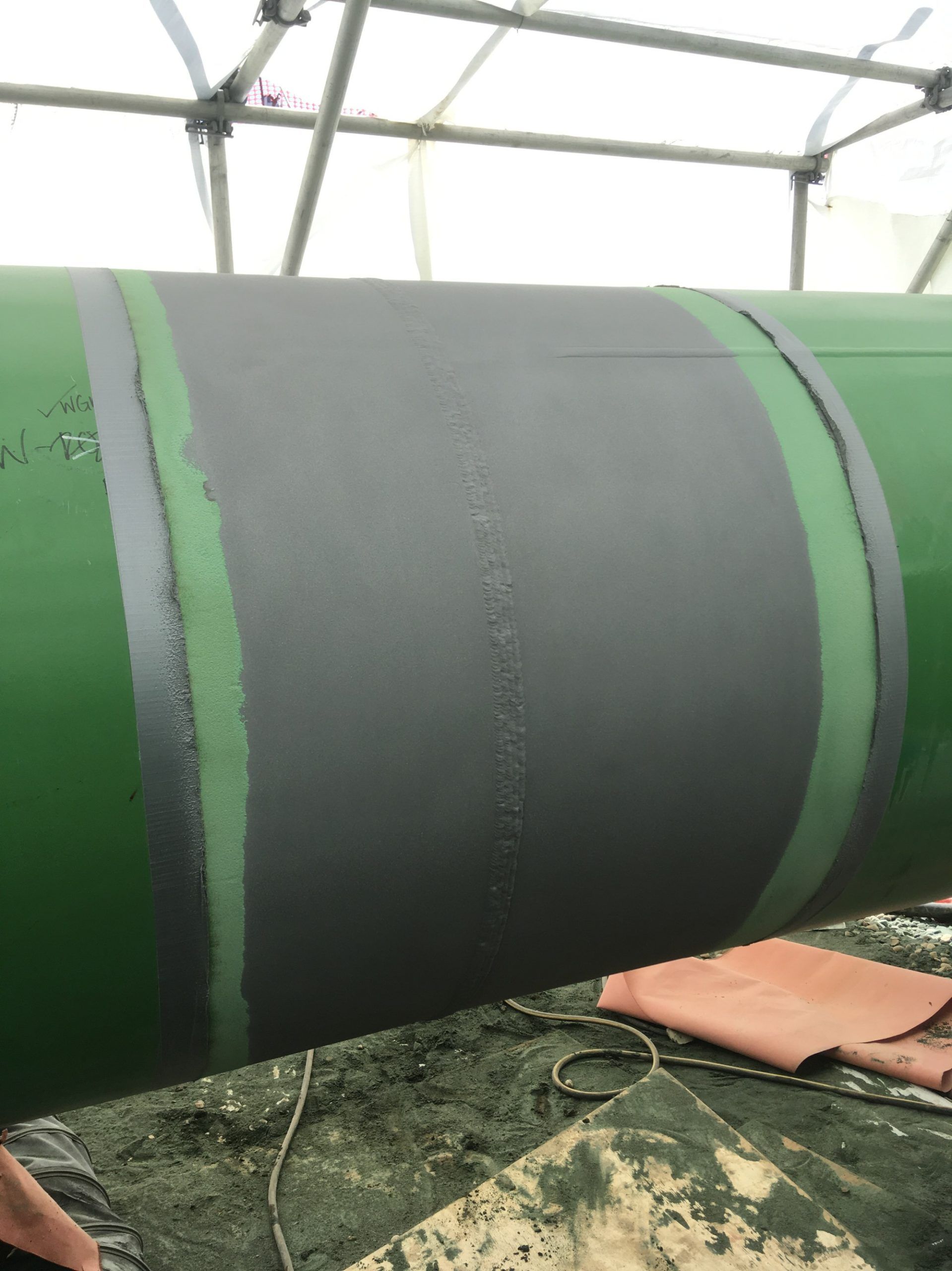 Close-up of freshly applied coating on a pipeline joint to prevent corrosion