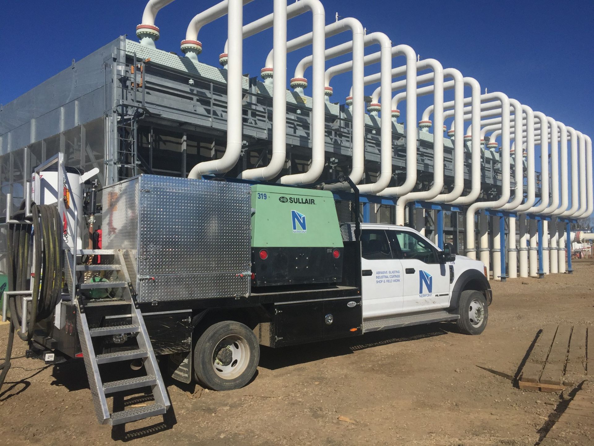 Industrial cooling system installation with visible coated piping and Norpoint service truck
