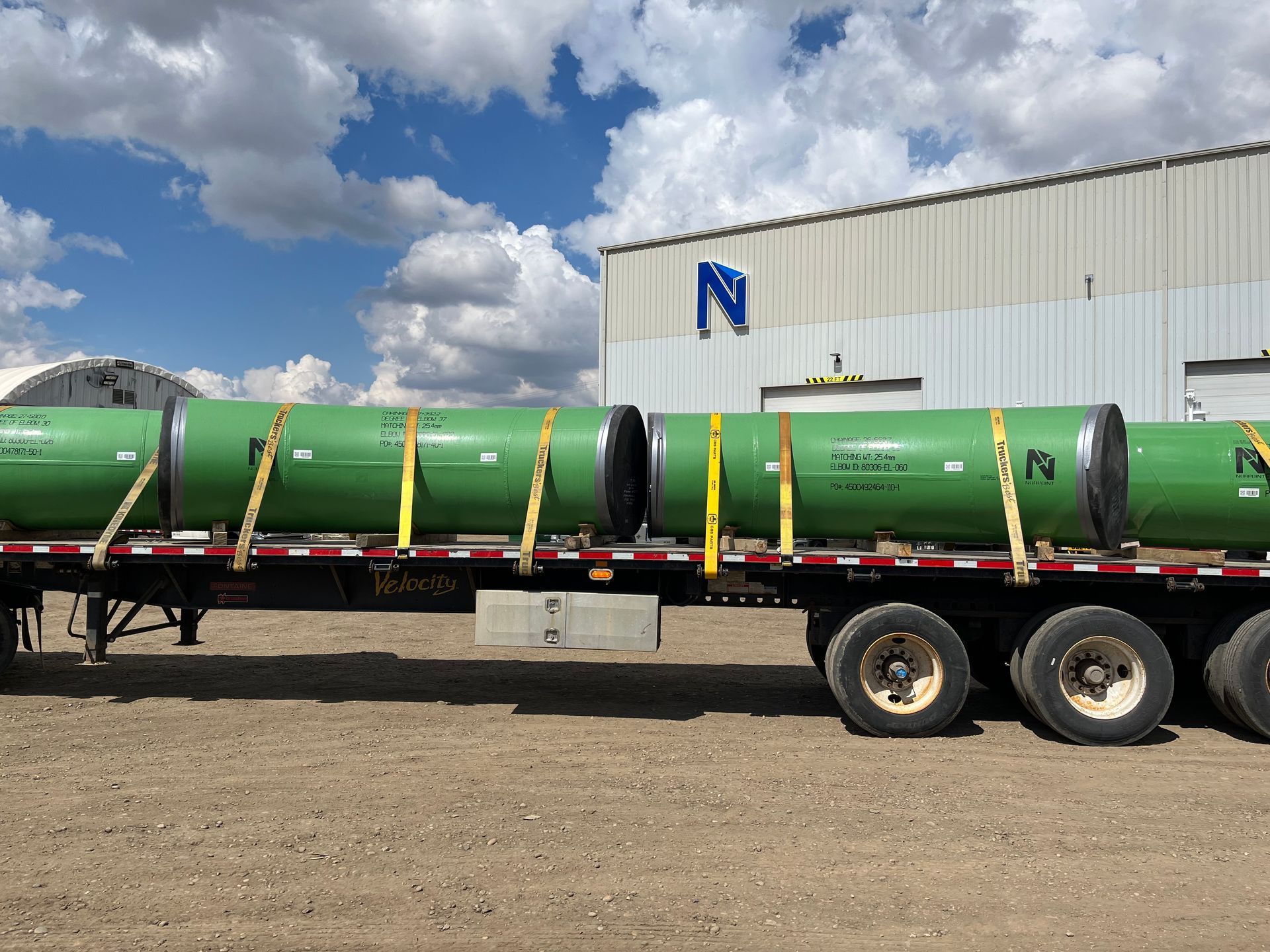 Green-coated pipes outside Norpoint’s facility post-blast cleaning and inspection process