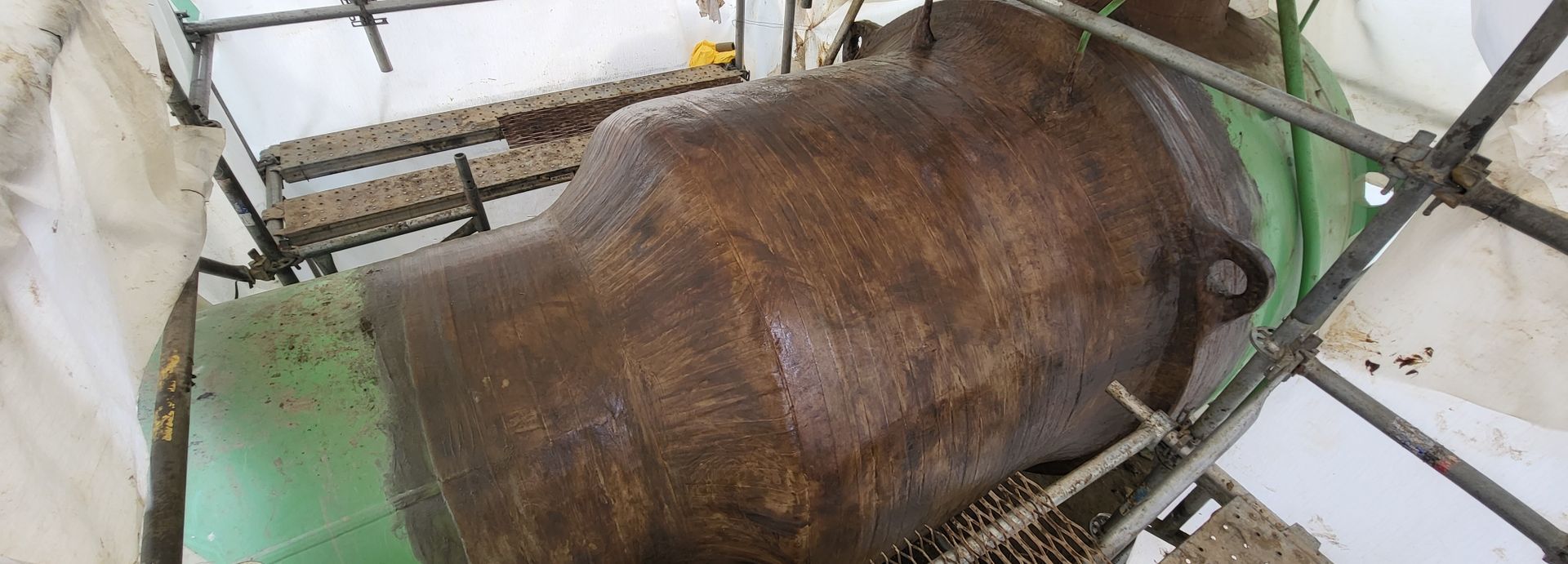Detailed image of a pipeline segment wrapped in a brown protective coating