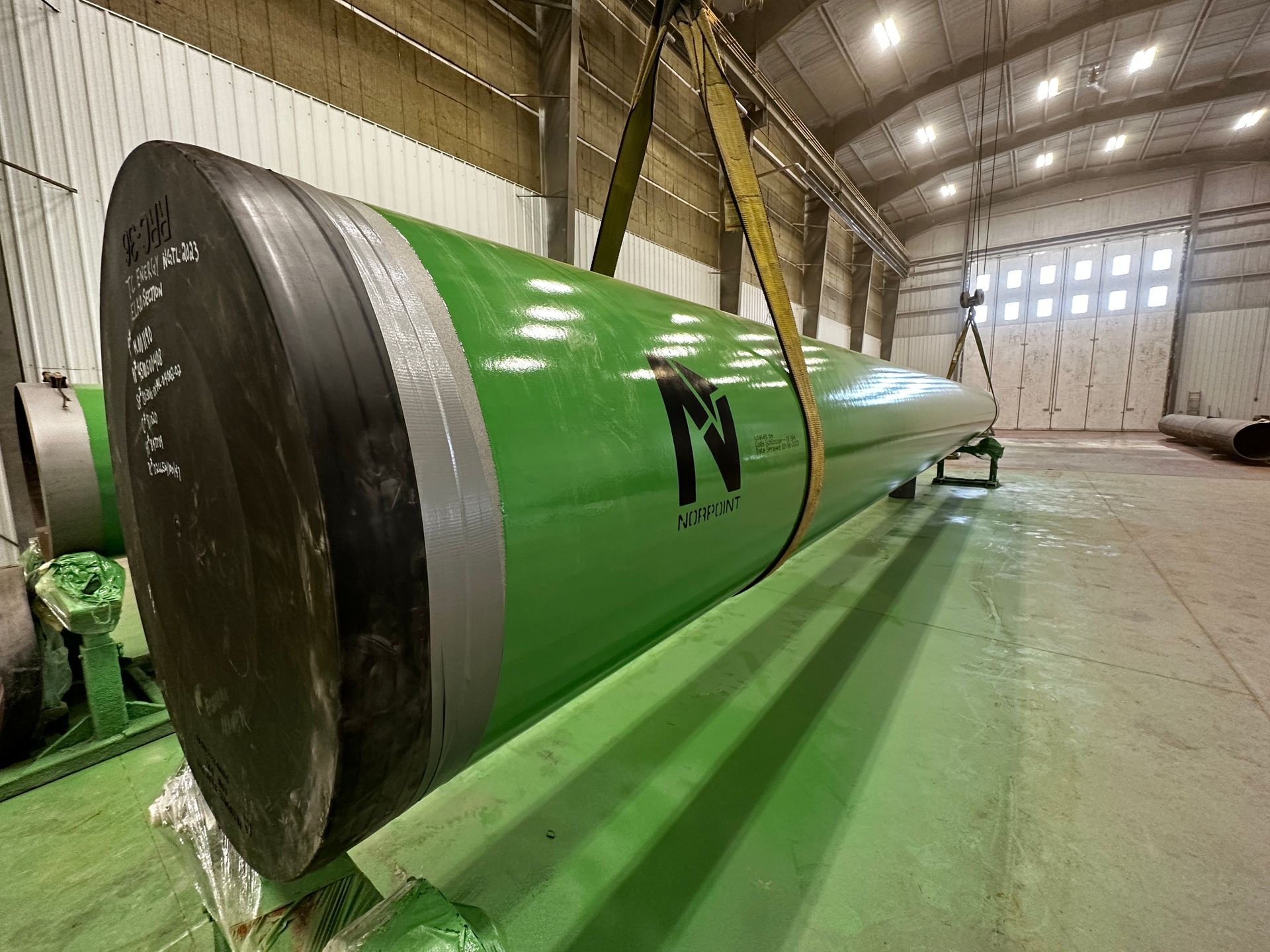 Large blast-cleaned pipe with Norpoint branding, prepared and loaded for transportation