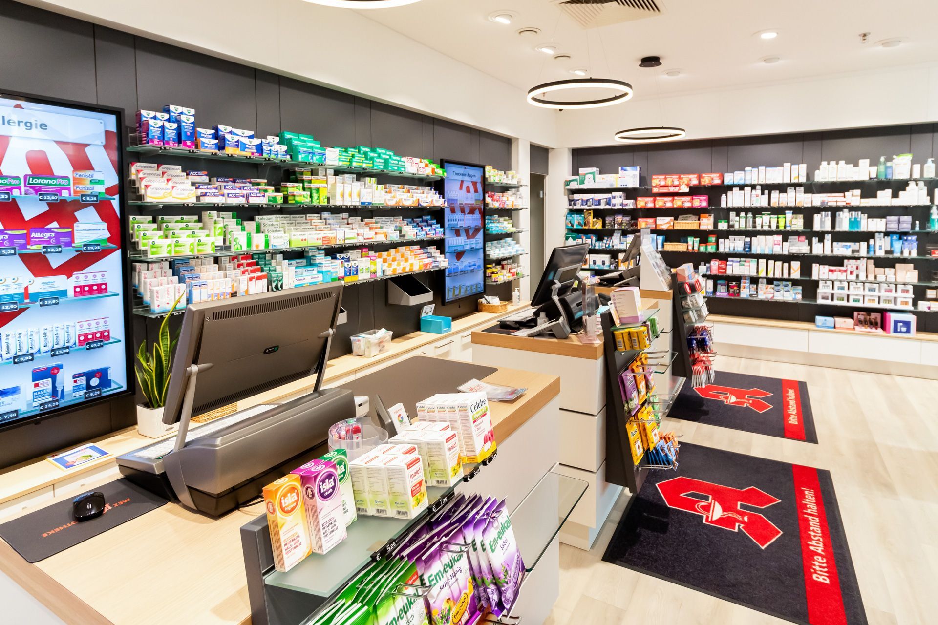 Eine Apotheke mit vielen Regalen und einer Kasse.