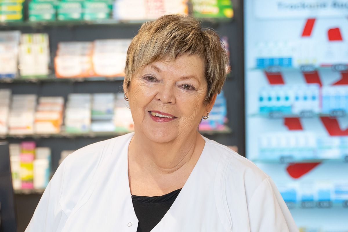 Eine Frau steht vor einem Regal in einer Apotheke.