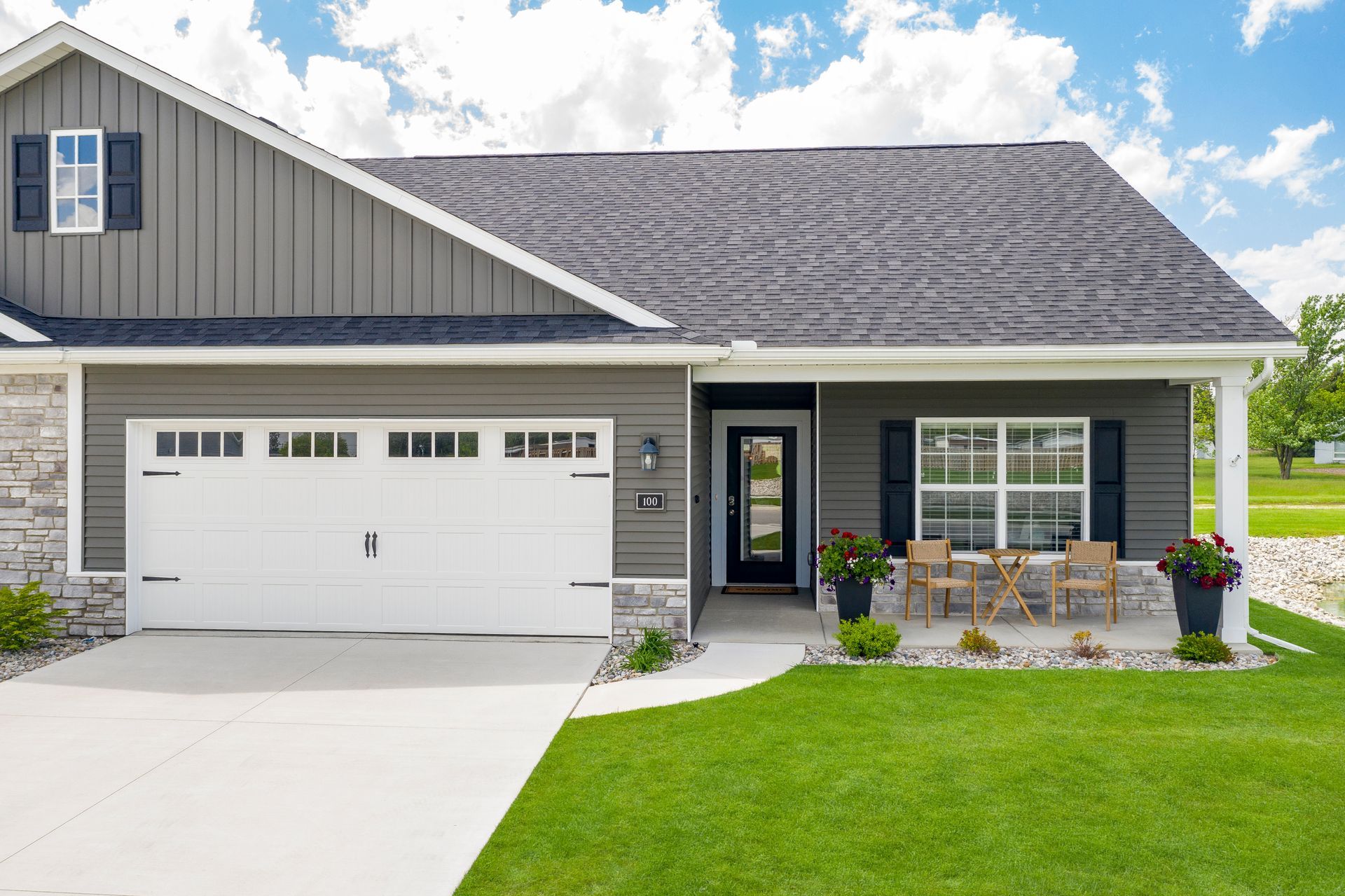 Photo of a home, showing a driveway, garage and the front door tucked in behind a porch area