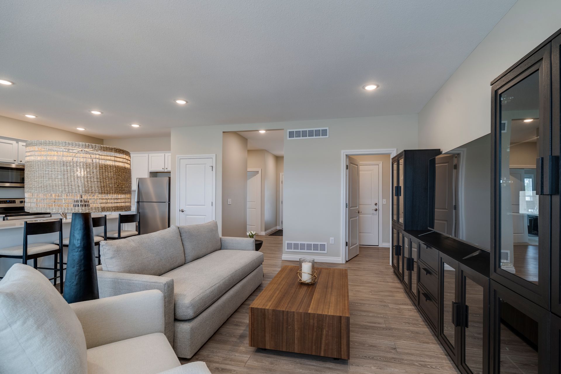 Photo of a living room, showing a cozy space, and a hallway in the background