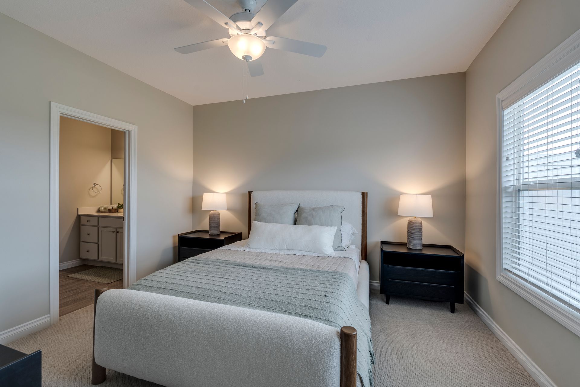 Photo of a master bedroom with the bathroom sink visible in the background