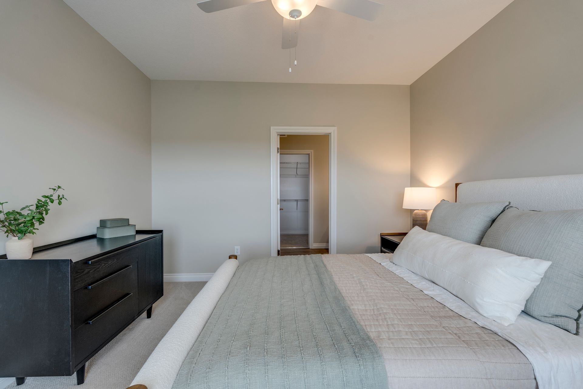 Photo of a bedroom with the walk-in closet visible in the background