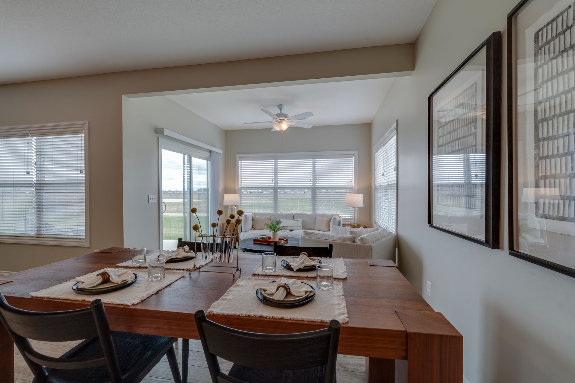 Photo of a dining table with a lounge in the background that has plenty of natural light