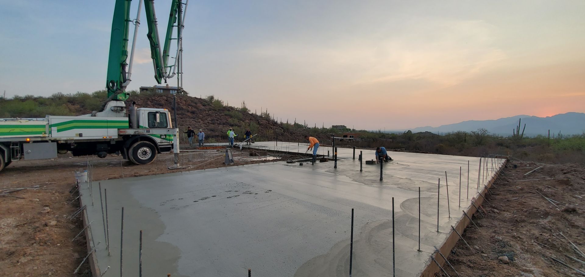 A concrete pump is being used to pour concrete on a construction site.