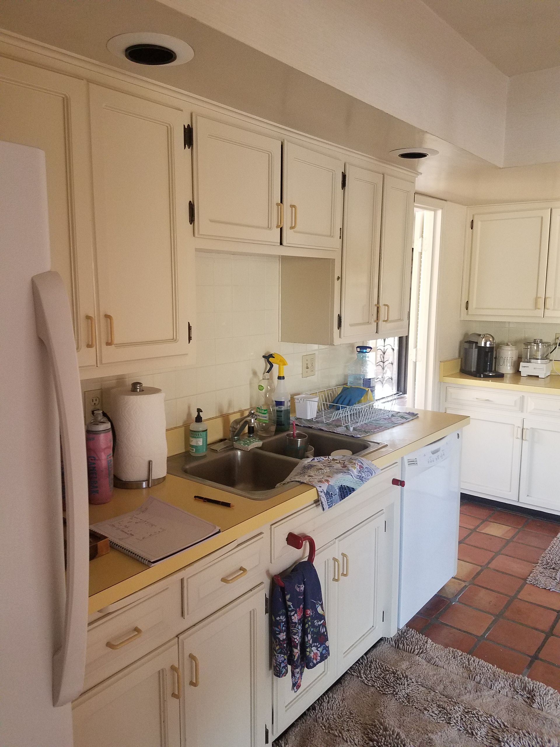 A kitchen with white cabinets and a dishwasher
