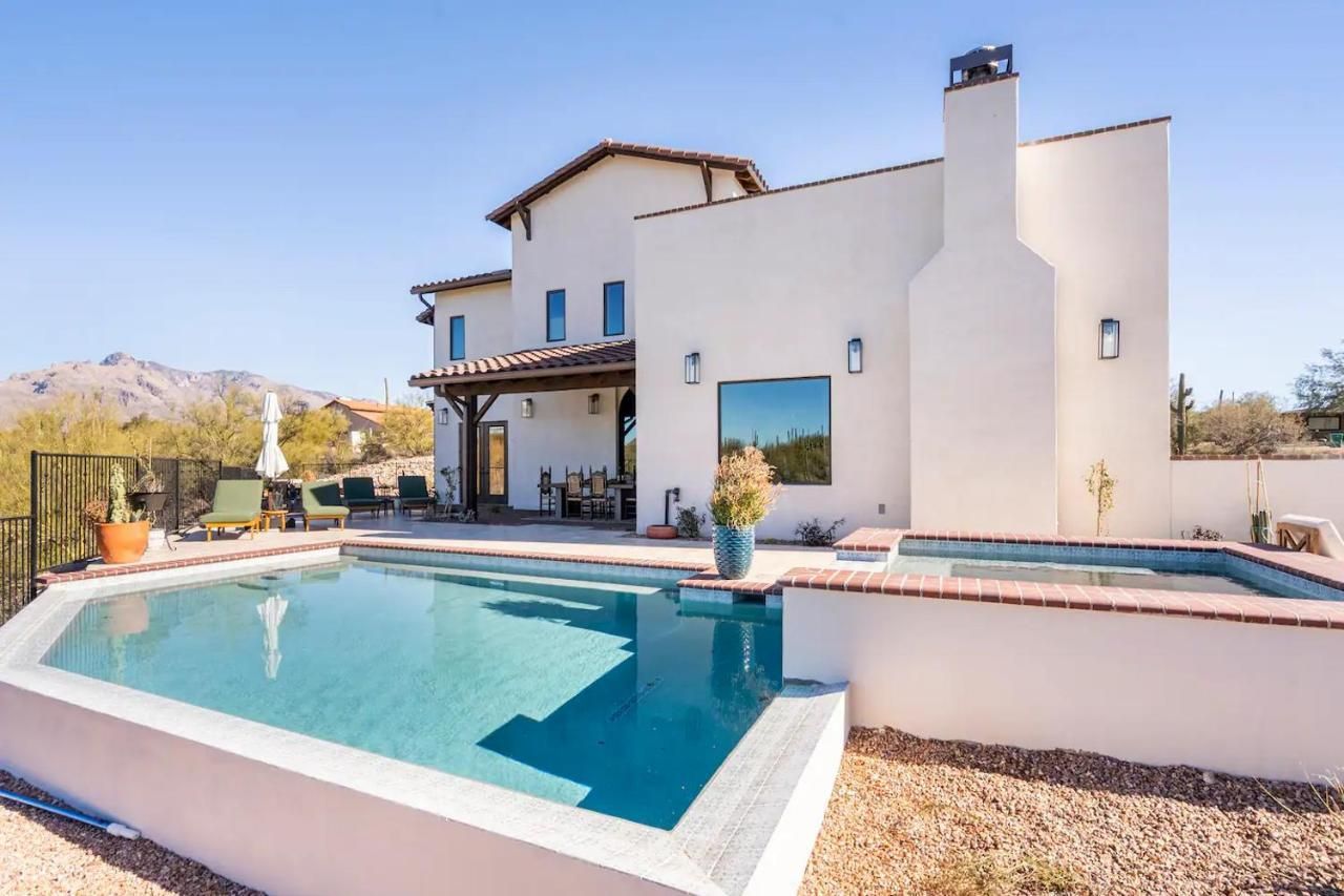 White stucco house with pool and spa on a sunny day.