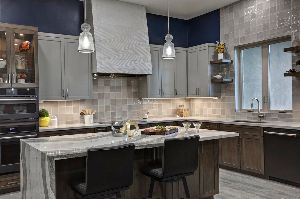 Modern kitchen with gray cabinets, island seating, and tile backsplash.