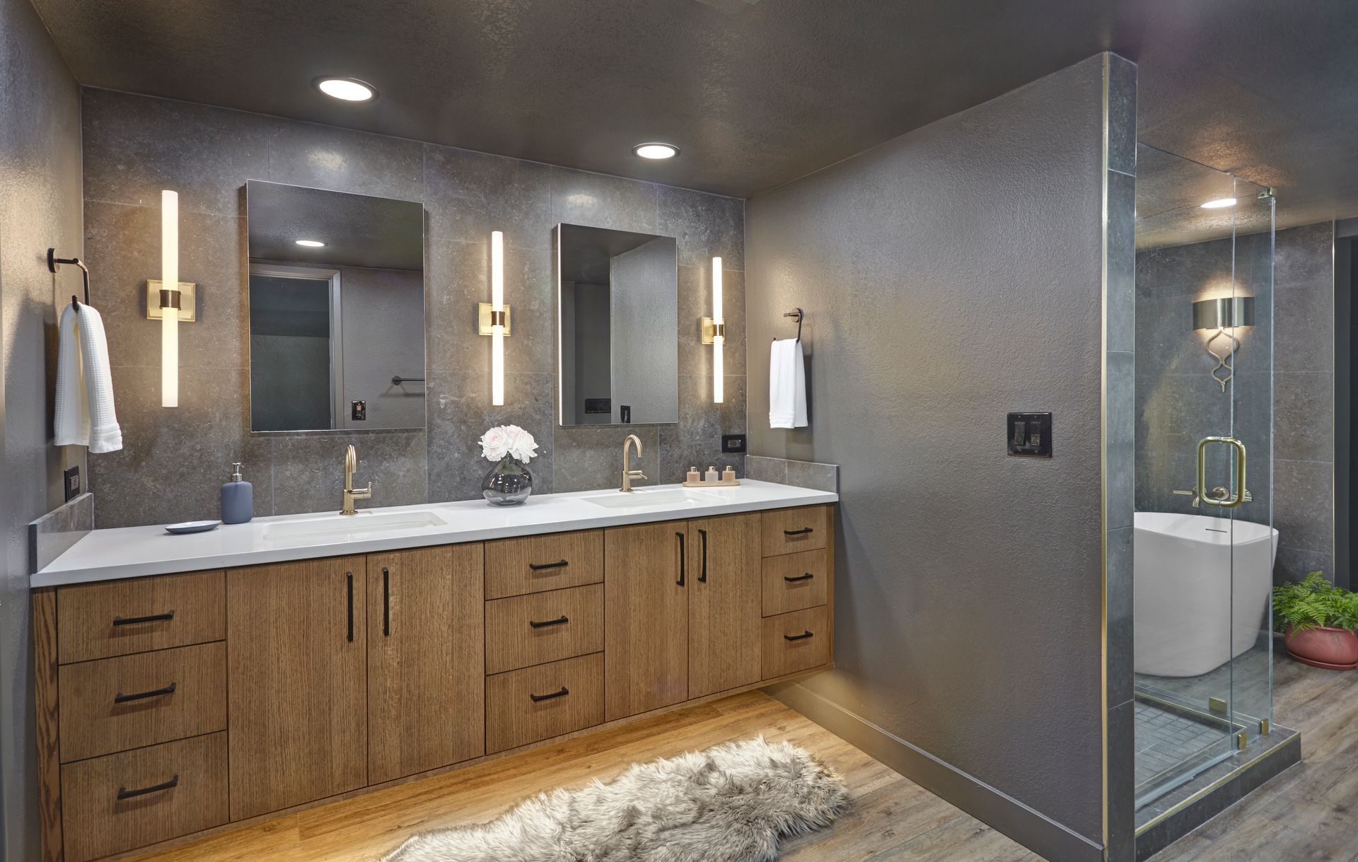 Modern bathroom with a double vanity, large mirrors, and glass shower.